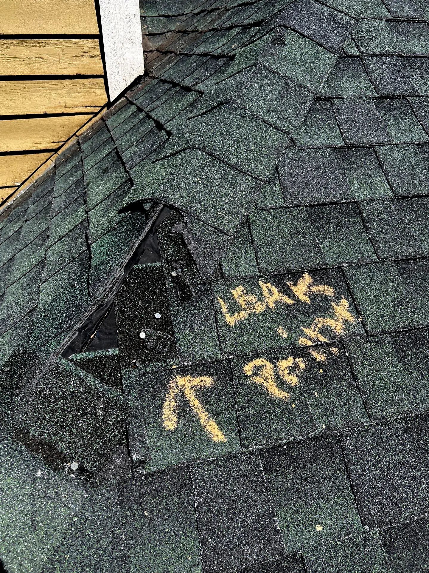 Leak in the asphalt shingle valley; missing shingles and exposed nails.