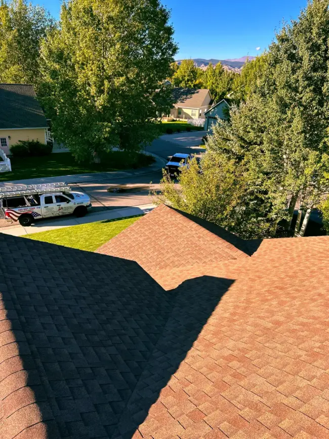 Roof replacement View from a residential rooftop in Littleton, CO showing new asphalt shingles. Replacement made by experts