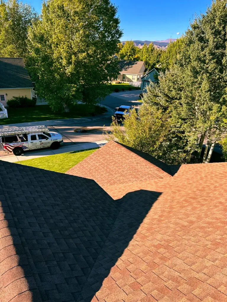 View from a residential rooftop in Littleton, CO showing new asphalt shingles. Replacement made by experts