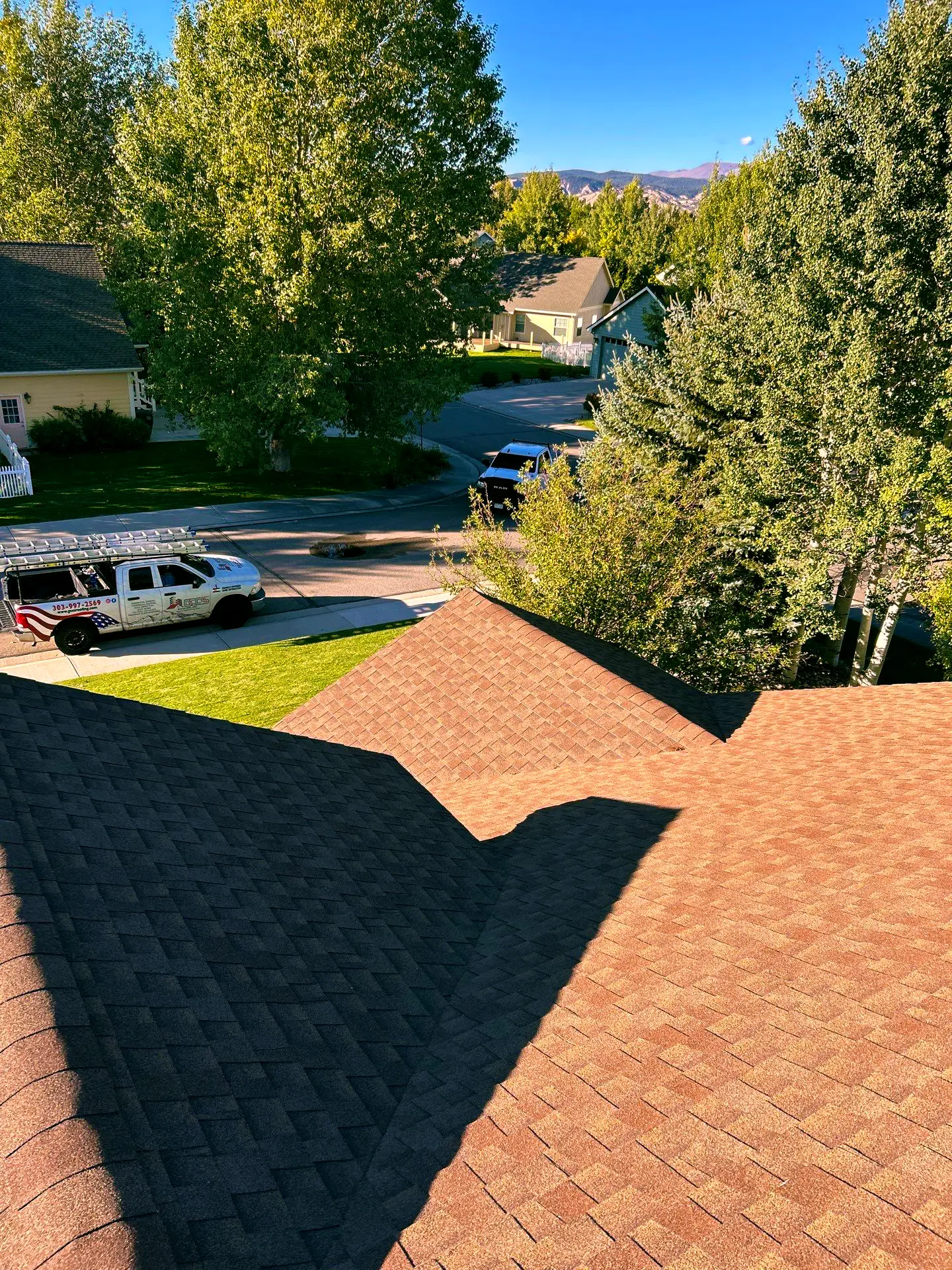 View from a residential rooftop in Littleton, CO showing new asphalt shingles. Replacement made by experts