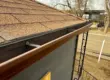Newly installed gutter along asphalt shingle roof of a home in Littleton, CO.