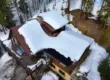 Snow-covered cabin roof in Littleton, CO showing heavy snow buildup and potential for winter roof leaks.