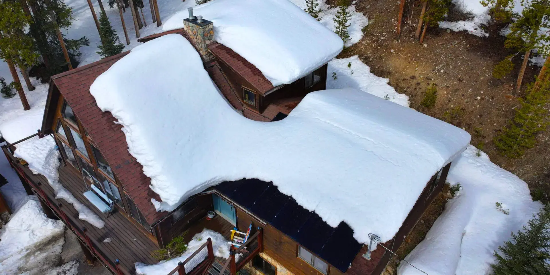 Snow-covered cabin roof Snow-covered cabin roof in Littleton, CO showing heavy snow buildup and potential for winter roof leaks.