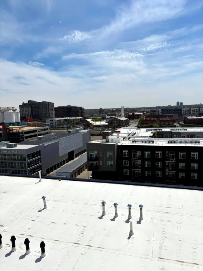 View of a large white commercial flat roof with multiple vents and equipment