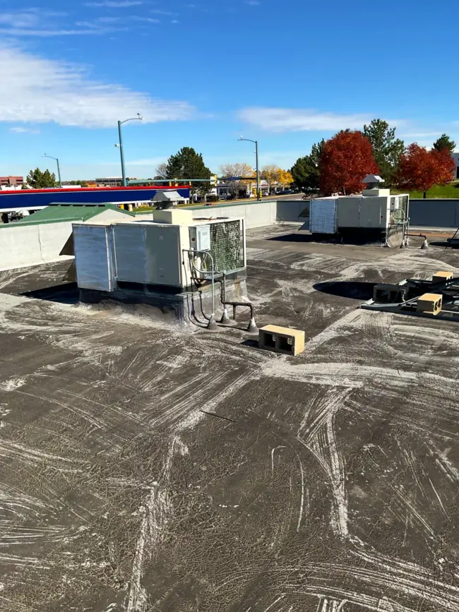 Flat commercial roof Flat commercial roof in Littleton, CO, showing HVAC units and surface wear during maintenance inspection.