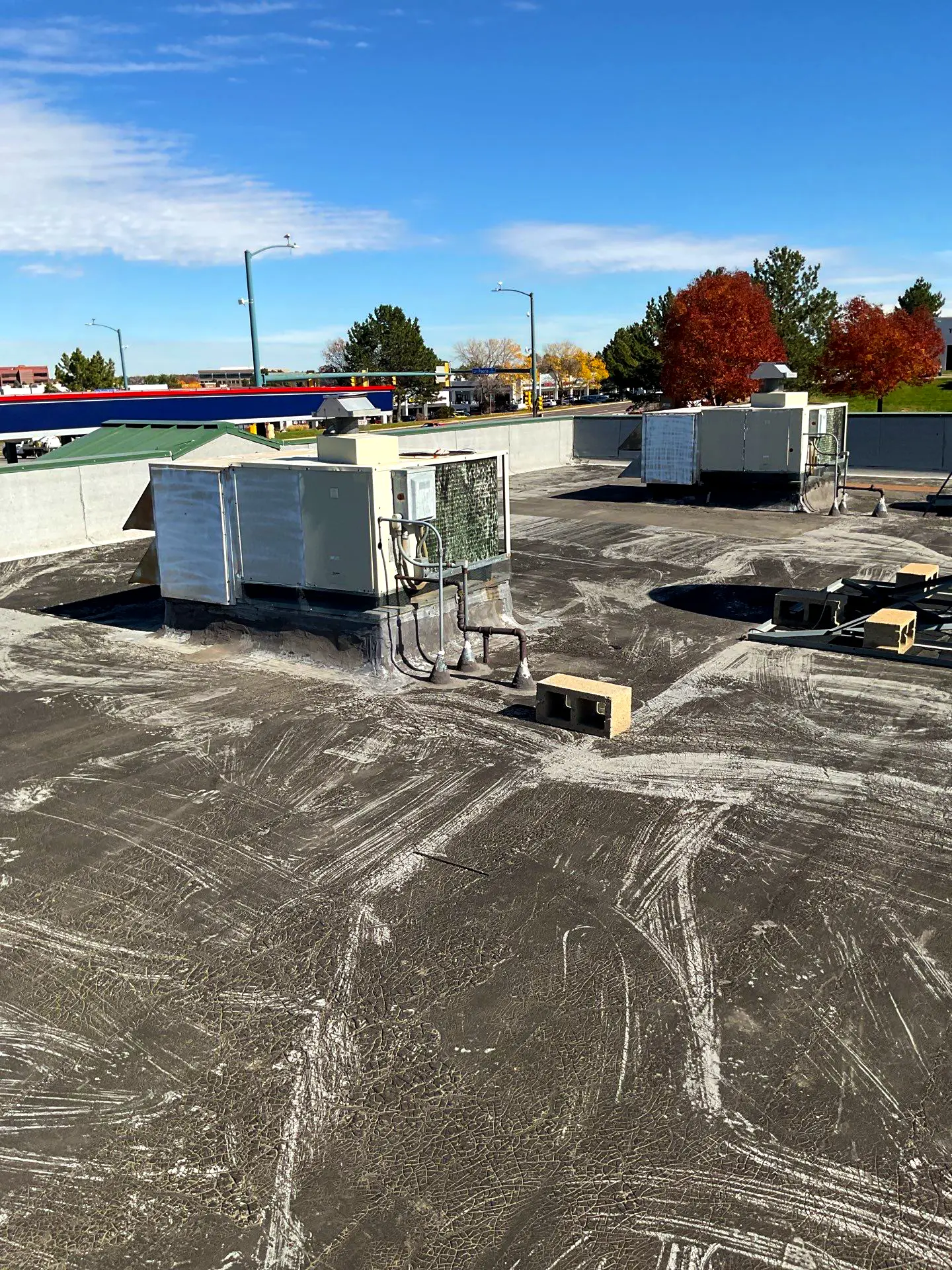 Flat commercial roof in Littleton, CO, showing HVAC units and surface wear during maintenance inspection.