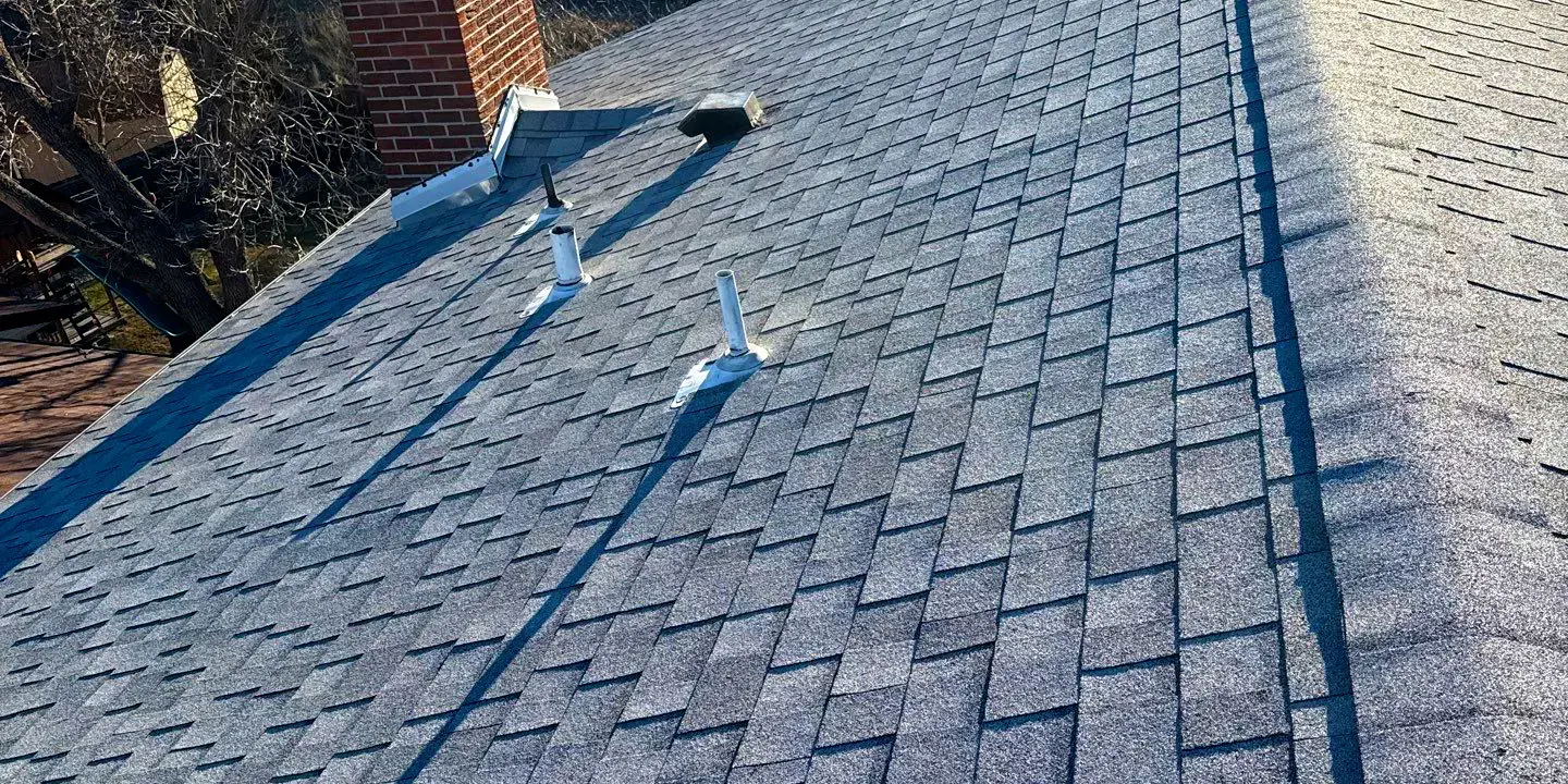 Residential asphalt shingle roof in clean condition, properly aligned and inspected for maintenance