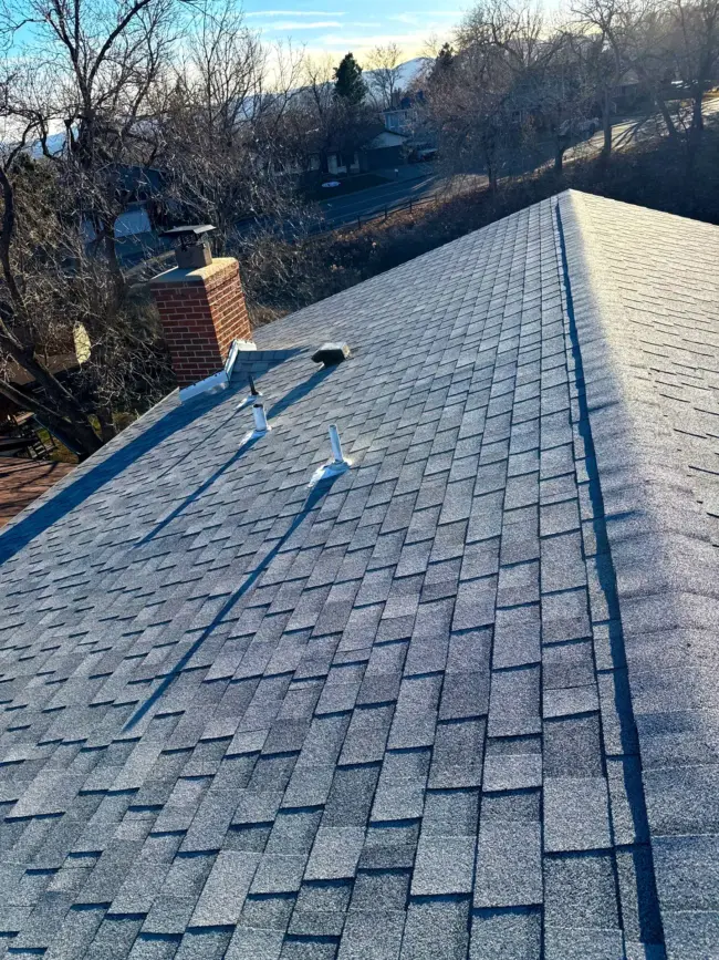 Residential asphalt shingle roof in clean condition, properly aligned and inspected for maintenance