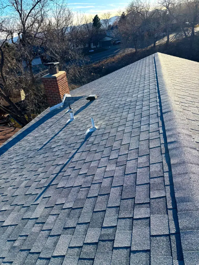 Residential asphalt shingle roof in clean condition, properly aligned and inspected for maintenance