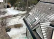Sloped residential roof with shake-style shingles and partial snow accumulation