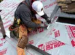 Professional roofer installing metal flashing at the base of a chimney, a critical detail to prevent leaks and ensure long-term roof durability in Littleton, Colorado.
