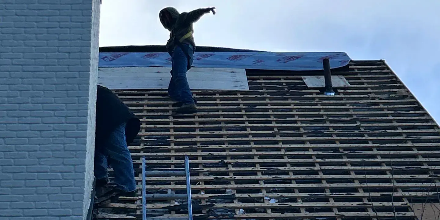Roofers removing old shingles Experienced roofers removing old shingles and preparing the roof structure for a full roofing repair and replacement on a residential home.