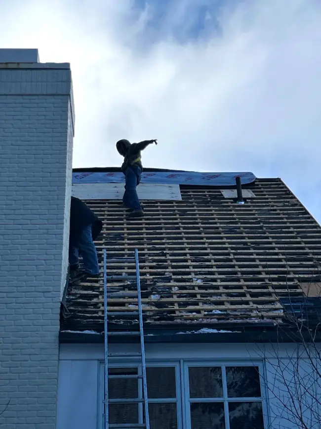 Roofers removing old shingles Experienced roofers removing old shingles and preparing the roof structure for a full roofing repair and replacement on a residential home.
