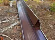 Metal roofing panels laid on the ground during a metal roof installation in a wooded area of Colorado, showing the work process of professional roofers.