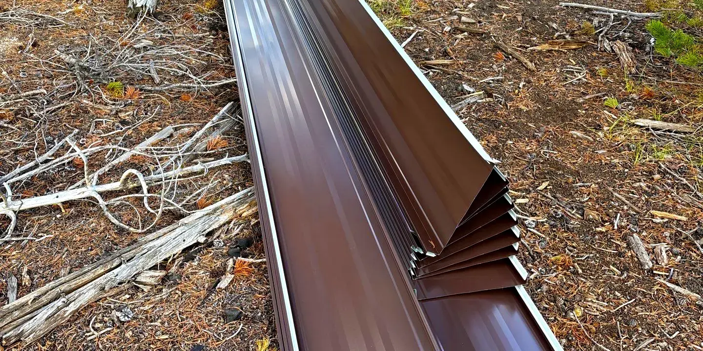 Metal roof Metal roofing panels laid on the ground during a metal roof installation in a wooded area of Colorado, showing the work process of professional roofers.