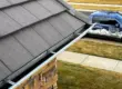 Close-up of metal gutters installed along the edge of a residential roof for proper rainwater drainage.