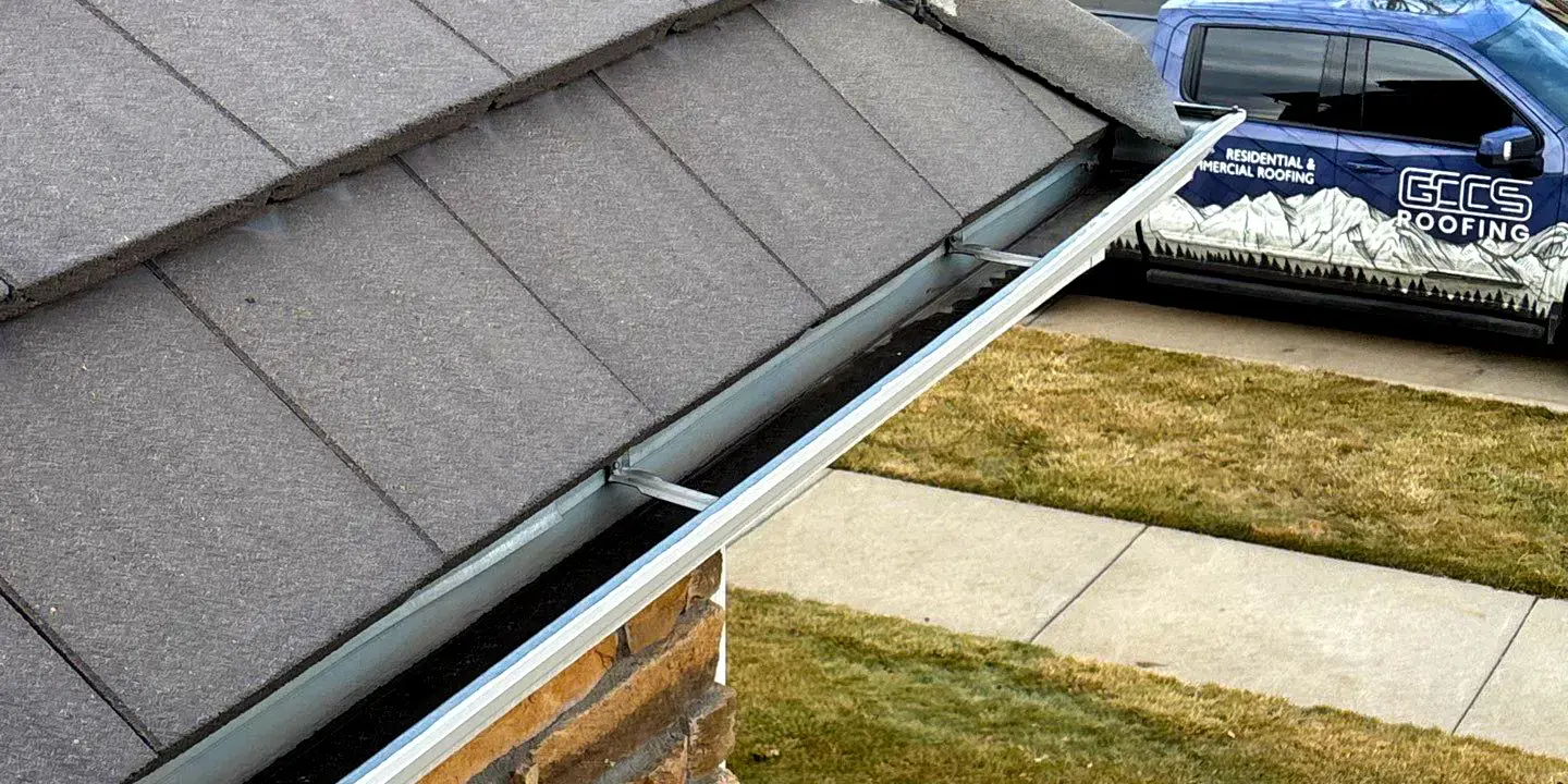 Close-up of metal gutters installed along the edge of a residential roof for proper rainwater drainage.