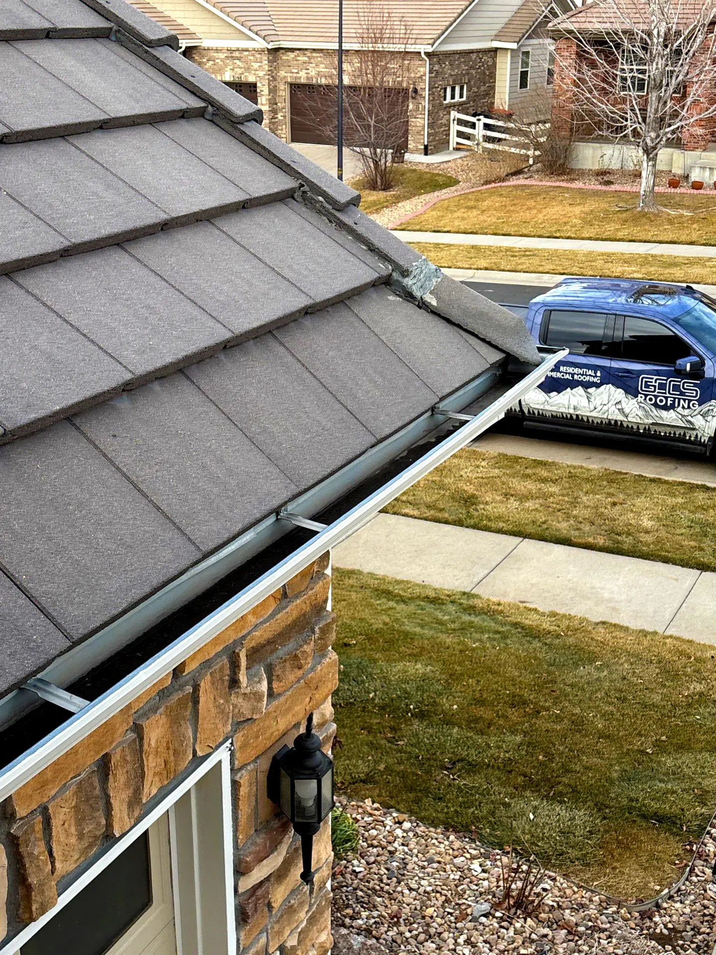 Close-up of metal gutters installed along the edge of a residential roof for proper rainwater drainage.
