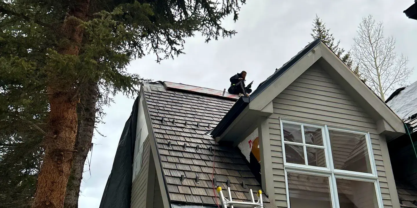 Skilled technicians performing professional roofing work on a residential property, demonstrating expert craftsmanship, proper safety equipment, and high-quality roof installation.