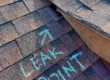 Close-up of asphalt shingle roof showing damage and a marked leak point during a professional roof repair inspection in Littleton, CO.