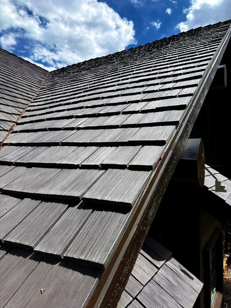 Dark shake-style roof on a mountain home, designed to provide durability and protection in demanding weather conditions.