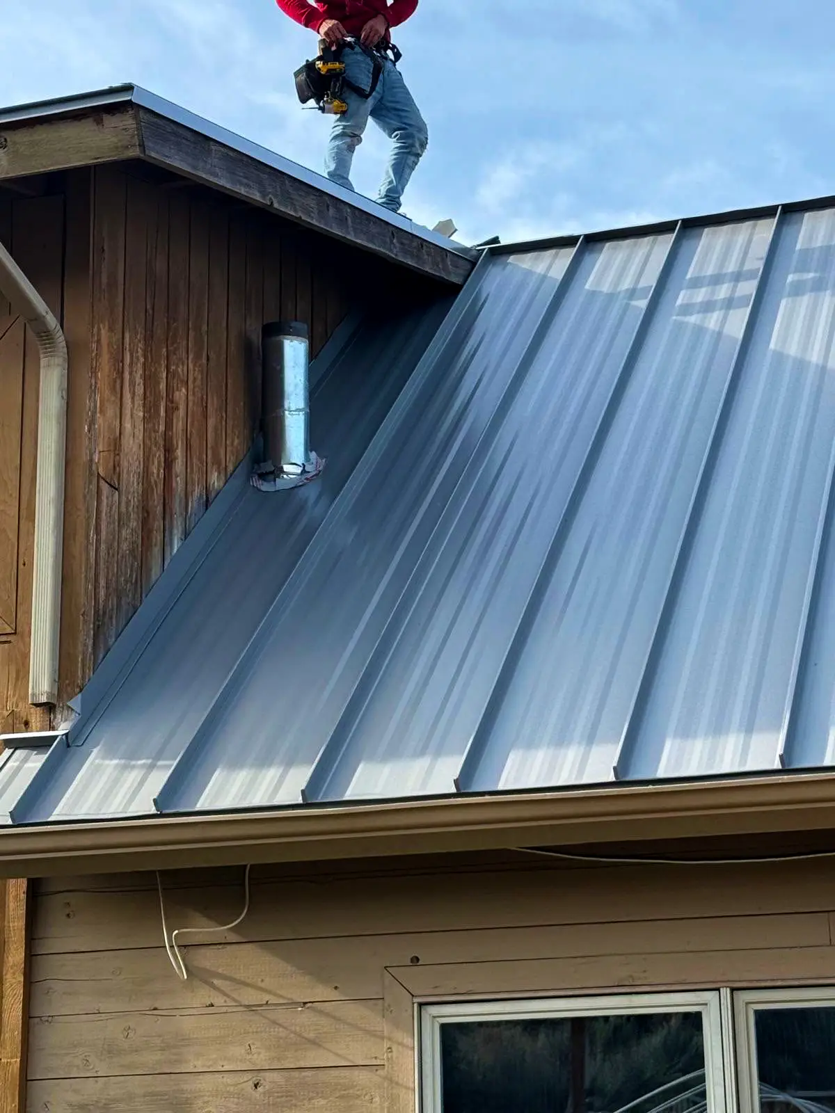 Standing seam metal roof installation on a mountain home, showing durable roofing details for wildfire-resistant protection.