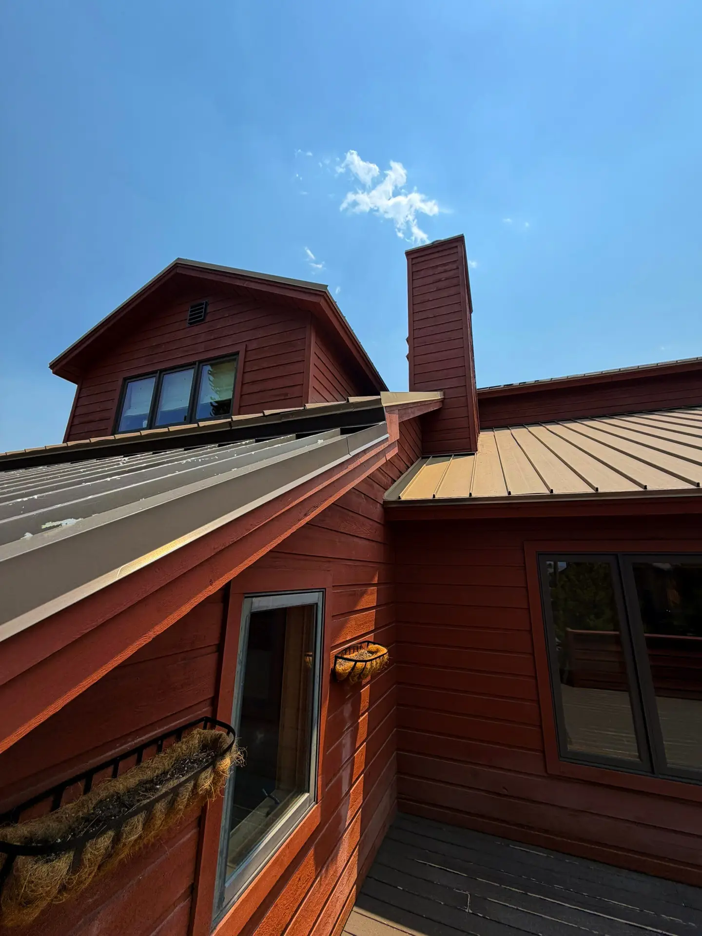 Metal roof and chimney detail on a mountain-style home in Avon, CO during a professional roofing inspection.